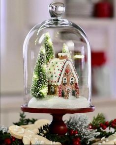 a christmas scene under a glass clochel on a table