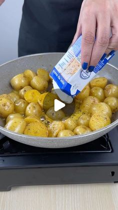 someone is adding seasoning to potatoes in a skillet