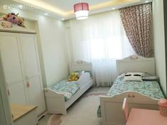 two twin beds in a small room with curtains on the windowsill and pink furniture