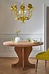 a dining room table with two chairs and a chandelier