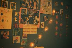 a wall covered in pictures and lights with posters on the wall behind it that have been decorated with string lights