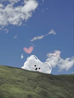 there is a cloud shaped like a bear on top of a hill with butterflies in the sky