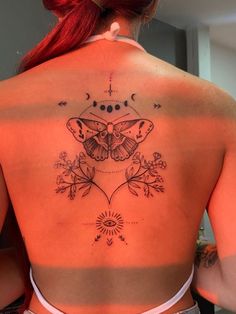 a woman with a butterfly tattoo on her back