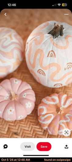 three decorative pumpkins sitting on top of a wicker table next to each other