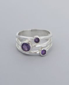 Three faceted amethyst stones sit nestled on textured bands of sterling silver. Gemstones are slightly different sizes for an artistic asymmetrical look. Gemstones measure 3mm to 5mm wide. Ring band is about 0.375 inches wide total. Available in sizes 6-9. Made in India. Triple gemstone ring Sterling silver with amethyst inlays Gemstone inlays are 3mm to 5mm wide Ring band is about 0.375 inches wide total Available in sizes 6-9 Made in India Due to the organic nature of gemstone, each ring will Divine Wisdom, Buddha Jewelry, Amethyst Stones, Malachite Jewelry, Nature Ring, Meaningful Jewelry, Wide Band Rings, Healing Energy, Amethyst Stone