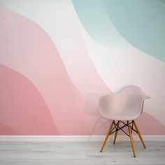 a white chair sitting in front of a pink and blue wall