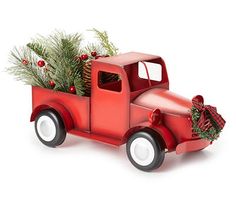 a red truck with a christmas tree in the back