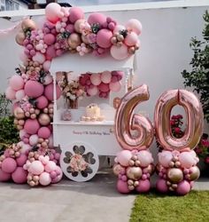 an ice cream cart decorated with pink and gold balloons for a 60th birthday party