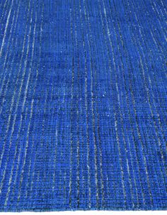 a blue rug with white lines on the top and bottom, is shown in full view