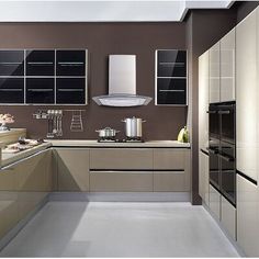 a modern kitchen with stainless steel appliances and white counter tops, along with brown walls