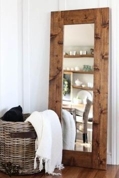 a mirror sitting on top of a wooden floor next to a basket