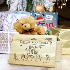 a brown teddy bear sitting in front of a wooden sign