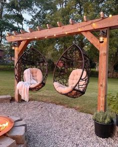 two hanging chairs in front of a fire pit