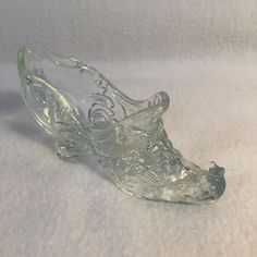 a glass shoe sitting on top of a white surface