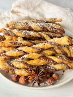 an assortment of desserts on a white plate with cinnamon sticks and star anise