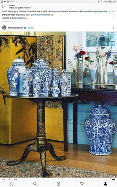 a table with blue and white vases sitting on top of it next to a wall