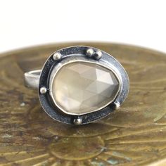 "This all sterling silver ring features a rose cut silver gray moonstone. The ring shank is about 3.5mm wide. The face of the ring is about 5/8 x 3/4\". The ring has been oxidized and selectively brushed to highlight the details.  The ring is US size 8.5. It can be enlarged on request in quarter sizes up to 9.5. Please read my shipping and policies page on the tab above or at this link: https://www.etsy.com/shop/laurenmeredith/policy?ref=shopinfo_policies_leftnav" Multiple Earrings, Moonstone Ring Sterling Silver, Agate Pendant Necklace, Ring Shank, Crazy Lace Agate, Metal Work, Agate Pendant, A Rose, Jewelry Gift Box