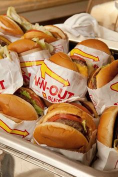 a tray filled with lots of hotdogs covered in cheese and ketchup