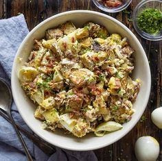 a white bowl filled with potato salad next to an egg