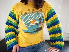 a woman sitting on top of a table wearing a yellow shirt