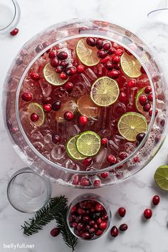 a platter filled with cranberry lemonade and limes next to two glasses of water