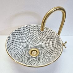 a white and gold colored basket with handles