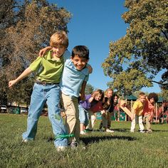 several children are playing with a frisbee in the grass on a sunny day