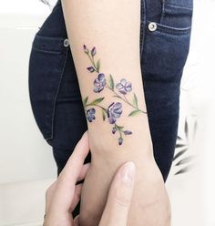 a woman with a flower tattoo on her arm