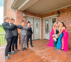 a group of people that are standing in front of a building with one person taking a picture