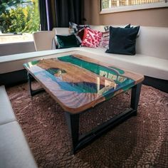 a glass table sitting on top of a rug in front of a couch and window