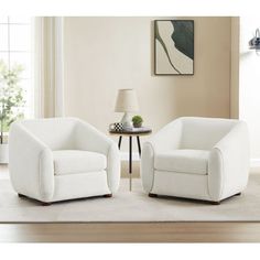 two white chairs sitting on top of a rug in a living room next to a table