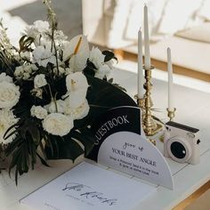 white flowers and candles sit on a table next to a sign that reads, let's book your best angle