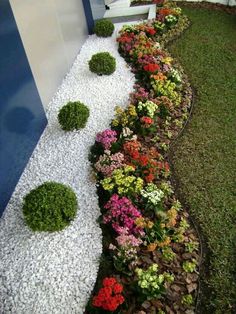 a garden with white gravel and colorful flowers