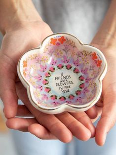 a person holding a small bowl in their hands with the words friends flowers i pick you written on it