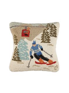 a pillow with a skier on it and pine trees in the backgroung