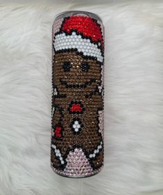 a cell phone case is decorated with bead and sequins, featuring a teddy bear wearing a santa hat