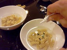 a person is eating noodles with a fork in their hand and another bowl full of them