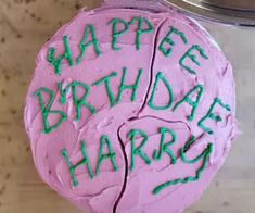 a pink cake with green frosting that says happy birthday harry on it's side