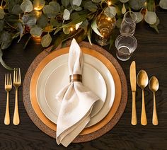 the place setting is set with silverware and gold - plated utensils