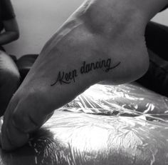 a person's foot with the words keep dancing tattooed on their left side leg