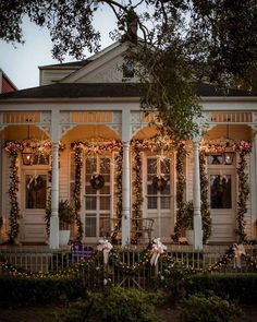 a white house decorated for christmas with lights and wreaths