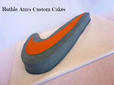 a cake shaped like a nike shoe sitting on top of a white tablecloth covered plate