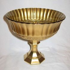 a golden bowl sitting on top of a white table