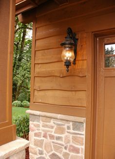 a light that is on the side of a building with a stone fire place in front of it