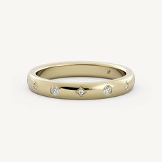 a yellow gold wedding band with three diamonds