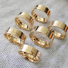 five gold rings sitting on top of a white cloth