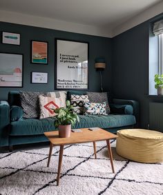 a living room with blue couches and pictures on the wall above them, along with a coffee table