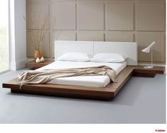 a white bed sitting on top of a wooden platform