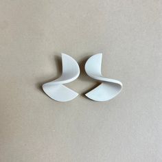 three pieces of white ceramic sitting on top of a table next to each other,