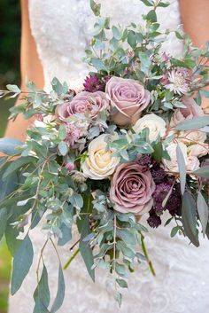 a bridal holding a bouquet of flowers and greenery